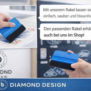 May include: A blue plastic squeegee tool featuring a black felt edge for applying stickers. The tool is shown in use on a surface and held in a hand, with text bubbles in German and the Diamond Design logo visible in the image composition.