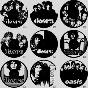 May include: A collection of black vinyl record clocks featuring band portraits and logos. The Doors and Oasis are among the bands represented. Each clock has a unique design, with the band's name and faces of the band members.