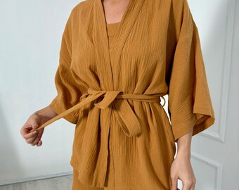 May include: A mustard yellow cotton robe with a matching set of shorts. The robe has a wide sash that ties at the waist.
