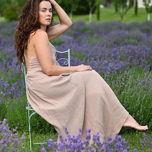 Taupe backless cotton maxi dress with deep V-neckline and open tie back. Made from breathable double gauze muslin, Oeko-Tex certified. Flowy A-line silhouette, perfect for boho bridesmaids, Greek goddess looks, and summer weddings. A lightweight gauze sun dress that’s handmade, easy to pack, and elegant for barefoot moments and garden gatherings.