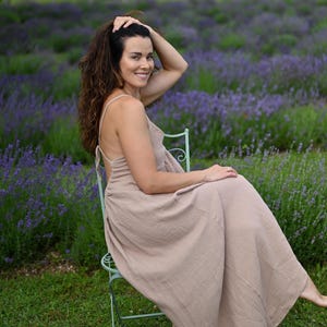Taupe backless cotton maxi dress with deep V-neckline and open tie back. Made from breathable double gauze muslin, Oeko-Tex certified. Flowy A-line silhouette, perfect for boho bridesmaids, Greek goddess looks, and summer weddings. A lightweight gauze sun dress that’s handmade, easy to pack, and elegant for barefoot moments and garden gatherings.