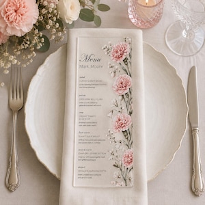 May include: A rectangular clear acrylic menu card featuring a printed floral design of pink carnations and white baby's breath along the right side. The text includes the heading Menu, Mark Moore, and a list of food courses with descriptions.