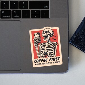 SVG PNG illustration of a skeleton holding a coffee cup with the humorous text Coffee first, Your bullshit later, designed in a playful style to celebrate Halloween. This quirky design combines a love for coffee with a cheeky message.