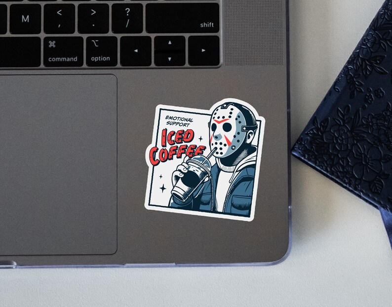 SVGPNG illustration of the famous horror character drinking iced coffee through his mask, labeled with the text Emotional Support Iced Coffee. This Quirky and humorous design blends the iconic Halloween horror with coffee culture