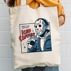 SVGPNG illustration of the famous horror character drinking iced coffee through his mask, labeled with the text Emotional Support Iced Coffee. This Quirky and humorous design blends the iconic Halloween horror with coffee culture