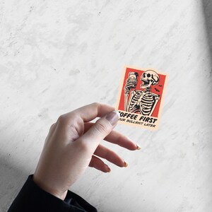 SVG PNG illustration of a skeleton holding a coffee cup with the humorous text Coffee first, Your bullshit later, designed in a playful style to celebrate Halloween. This quirky design combines a love for coffee with a cheeky message.