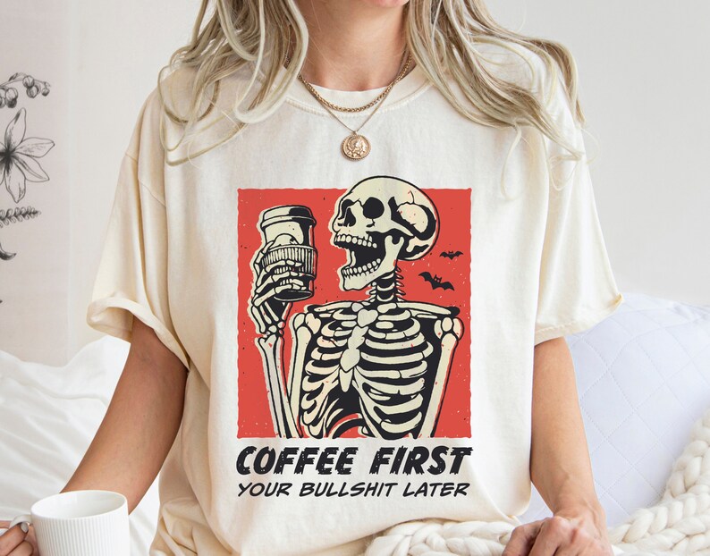 SVG PNG illustration of a skeleton holding a coffee cup with the humorous text Coffee first, Your bullshit later, designed in a playful style to celebrate Halloween. This quirky design combines a love for coffee with a cheeky message.