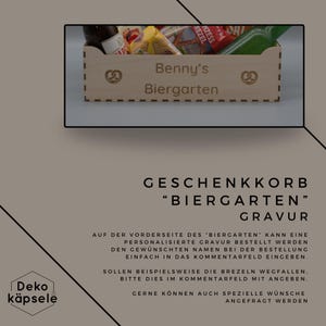 Puede incluir: Una cesta de regalo de madera con el texto "Benny's Biergarten" grabado en la parte delantera. La cesta est&aacute; llena de varios art&iacute;culos, incluyendo pretzels, cerveza y otros aperitivos. El texto "GESCHENKKORB "BIERGARTEN" GRAVUR" se muestra debajo de la imagen.