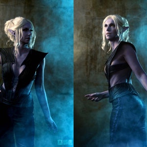 May include: A woman with long blonde hair and pointed ears is wearing a black leather outfit with a low-cut neckline. She is standing in a smoky, blue-lit room.