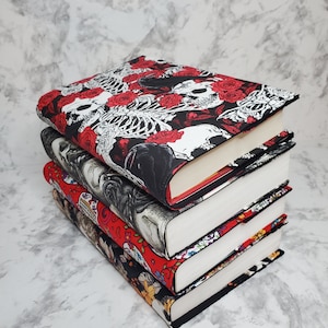 May include: A stack of four book covers with different designs. The top cover features a black and white skull and rose pattern. The second cover features a black and white skull and floral pattern. The third cover features a red and black floral pattern. The fourth cover features a black and white floral pattern.