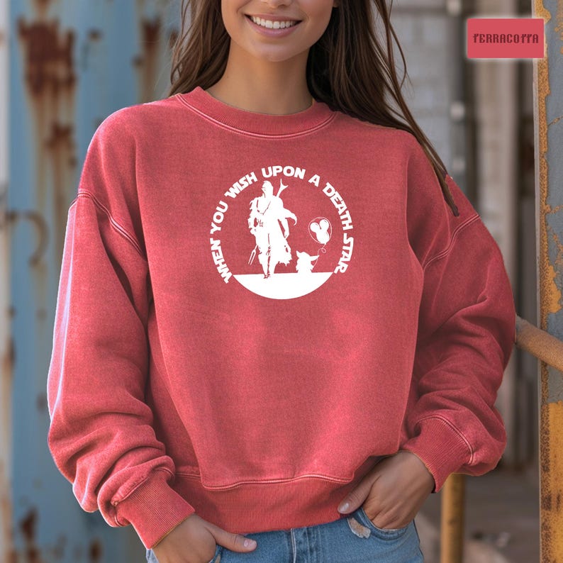 May include: Red sweatshirt with a white graphic of a character from the Star Wars franchise. The graphic says "When you wish upon a death star".