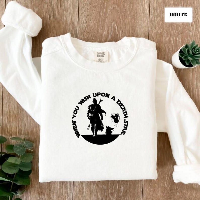 May include: White sweatshirt with a black graphic of a character from the Star Wars franchise. The graphic includes the text "When you wish upon a Death Star".