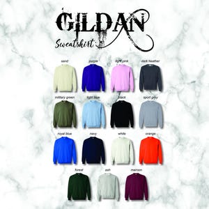 May include: A color chart of Gildan sweatshirts in various colors, including sand, purple, light pink, dark heather, military green, light blue, black, sport grey, royal blue, navy, white, orange, forest, ash, and maroon.