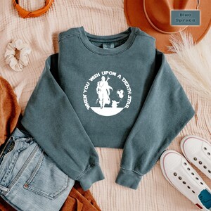 May include: A dark blue sweatshirt with a white graphic of a character from the Star Wars franchise. The graphic says "When you wish upon a death star".