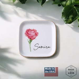 Puede incluir: Bandeja cuadrada de cer&aacute;mica blanca con borde dorado, con una rosa rosa acuarela y el nombre "Samira" en escritura cursiva. La bandeja est&aacute; marcada "Made in the USA" y "Made with Love".