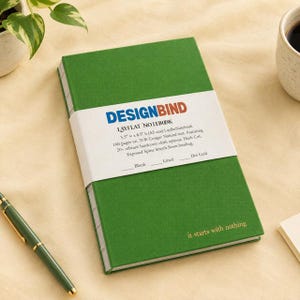 May include: A green hardcover notebook with an exposed Smyth sewn spine and the text 'it starts with nothing' in gold foil. A white paper band wraps around the center, featuring the text 'DESIGNBIND LAYFLAT NOTEBOOK 5.5" x 8.5" h'.