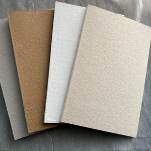 Quaderno con copertina realizzata a mano in carta riciclata al 100%, dorso a vista, cucitura Smyth e personalizzazione gratuita con timbro a caldo.