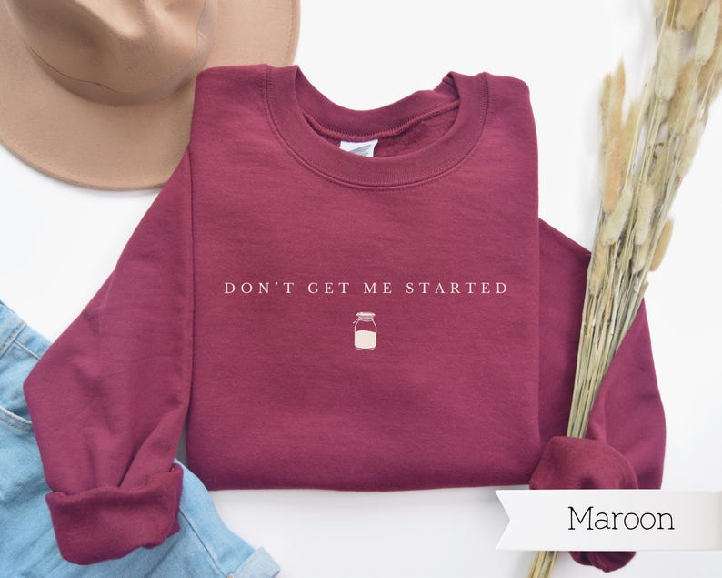 May include: Maroon sweatshirt with the text "Don't get me started" and a small illustration of a jar.