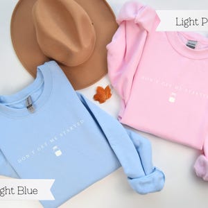 May include: Two sweatshirts, one light blue and one light pink, with the text "Don't get me started" and a small milk carton graphic printed on the front.