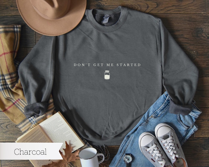May include: A charcoal grey sweatshirt with the text "Don't Get Me Started" and a small illustration of a mason jar.