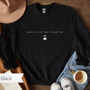 May include: Black long-sleeved sweatshirt with the text "Don't get me started" and a small milk jar graphic.