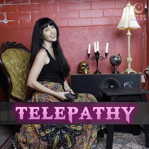 May include: A woman with long black hair sits in a chair wearing a black tank top and a colorful paisley skirt. She is holding a black handheld device. The text "TELEPATHY" is in pink letters on a black background.