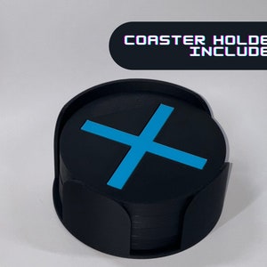 May include: A set of black coasters with a blue X design, stacked in a black holder. Coaster holder included.