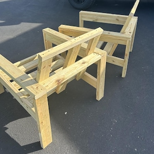Puede incluir: Dos sillas de madera sin terminar apiladas una encima de la otra. Las sillas son de madera marr&oacute;n claro y tienen un dise&ntilde;o sencillo.