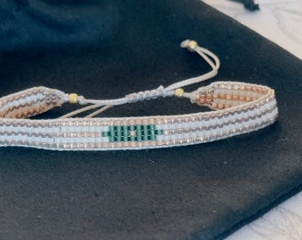 Beaded loom bracelet with cream, emerald and gold Miyuki Japanese beads. Easy slide clasp with matching nylon thread.