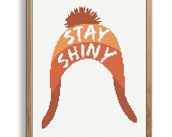 May include: Cross stitch pattern of a beanie with a pom pom and the text "Stay Shiny" in white.