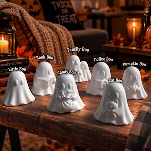 Könnte beinhalten: Eine Sammlung weißer Keramik-Geisterfiguren mit den Bezeichnungen Little Boo, Book Boo, Family Boo, Candy Boo, Coffee Boo, Cat Boo und Pumpkin Boo. Jeder Geist hat eine einzigartige Pose, wie das Halten eines Buches, einer Tasse, einer Katze oder eines Kürbisses.
