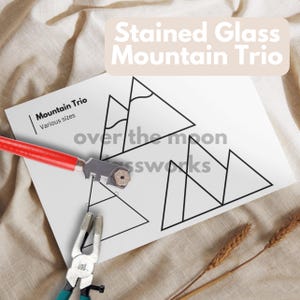 May include: A black and white printable template for stained glass mountain trio. The template includes three different mountain designs with the text "Mountain Trio" and "Various sizes".