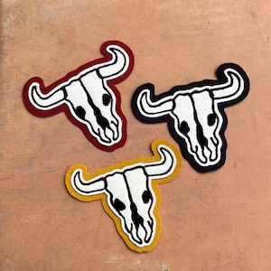 May include: A set of three ceramic mugs with a speckled, matte finish. The mugs are in shades of cream, light gray, and dark gray. Each mug has a simple, minimalist design, perfect for coffee or tea.