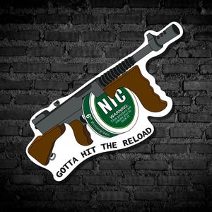 May include: A sticker featuring a cartoon illustration of a gray Tommy gun with brown handles. A green and white circular label reads "NIC" and "Wintergreen" with a warning. The text "GOTTA HIT THE RELOAD" is below the gun.