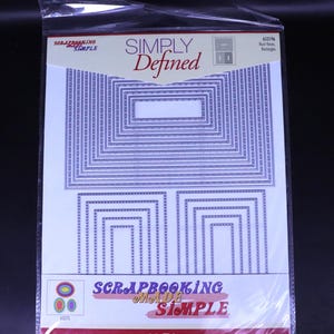 Puede incluir: Un paquete de troqueles de scrapbooking con el texto "SIMPLY Defined" y "SCRAPBOOKING Made Simple". Los troqueles son de varios tamaños de rectángulos y óvalos. Los troqueles son morados y blancos.