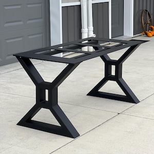 May include: Black metal table base with a rectangular top and an X-shaped design. The base is made of sturdy metal and has a black finish.