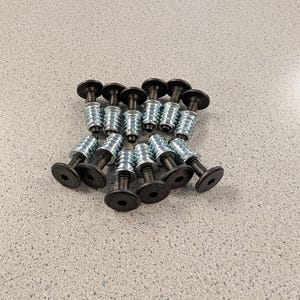 May include: A white ceramic mug with a black handle and the text "But First, Coffee" in a black, bold font. The mug is sitting on a wooden surface. The mug is approximately 4 inches tall.