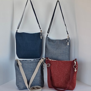 BOLSO AMY BUCKET con exterior de tela tapizada, forro estampado de algodón, correa cruzada ajustable y billetera incorporada en bolsillo interior con cremallera.