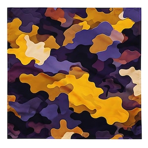 May include: Square fabric with a colorful abstract camouflage pattern. The design features overlapping shapes in shades of yellow, purple, brown, and cream. The fabric has a smooth texture and a modern aesthetic.