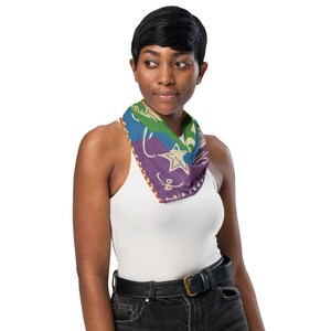 May include: A colorful bandana with a star and floral design. The bandana features a mix of blue, green, purple, and orange hues. The star is white, and the edges are lined with a dotted pattern. The bandana is worn around the neck.