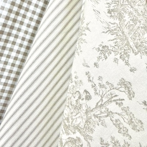 May include: Three folded pieces of fabric displayed side by side. The first features a brown and white gingham check pattern, the second shows thin brown and white vertical stripes, and the third displays a brown toile print on a white background.