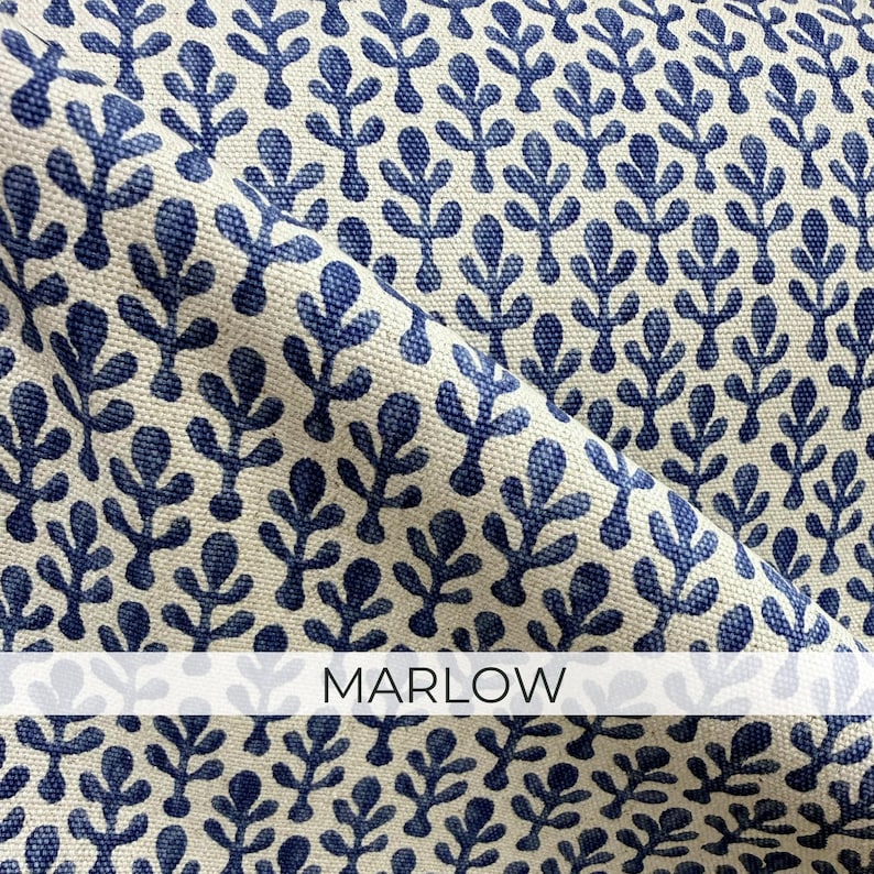 a close-up view of a fabric with a repeating pattern of blue leaf-like shapes on a beige background. The fabric appears to be made of a material with a textured surface, and the pattern is quite intricate. The word "MARLOW" is written in white text at the bottom of the image.