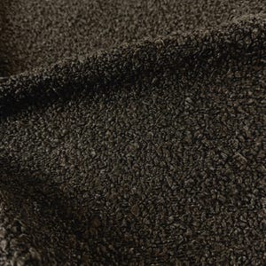 May include: Close-up of a dark brown textured fabric with a slightly rough surface.