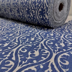 a close-up view of a fabric with a blue and white patterned design, featuring intricate swirls and curves.