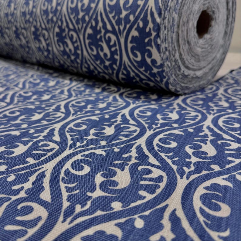 a close-up view of a fabric with a blue and white patterned design, featuring intricate swirls and curves.