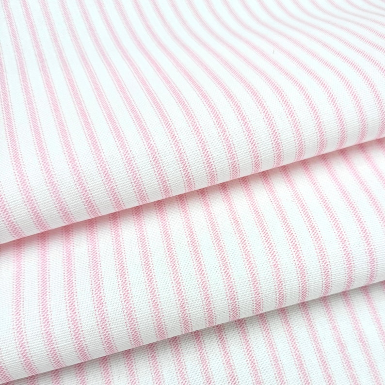 a close-up view of a fabric with pink and white striped patterns.