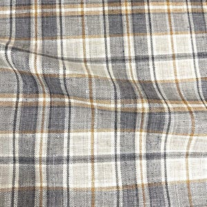 May include: A close-up of a fabric with a plaid pattern in shades of brown, gray, and white.