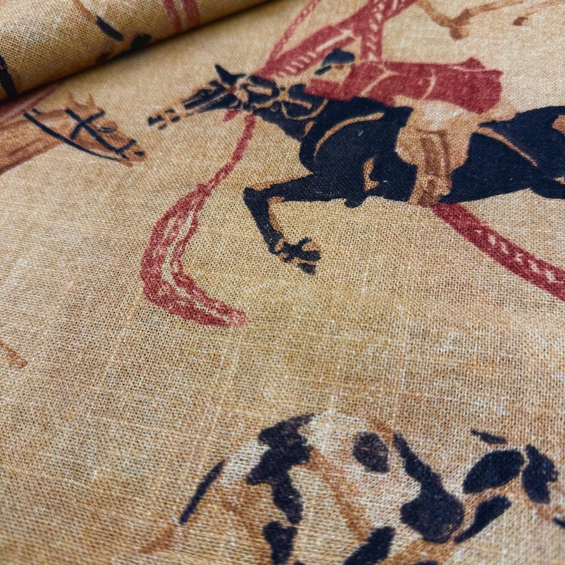 May include: Tan fabric with a repeating pattern of horses and riders in black, brown, and red. The horses are in motion, and the riders are depicted in a stylized manner. The fabric has a textured appearance, suggesting a linen or similar material.