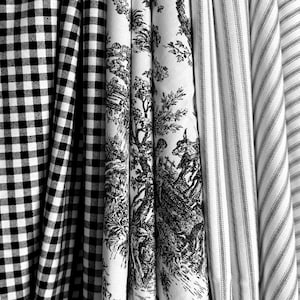 May include: A collection of folded fabrics in black and white patterns. The patterns include a classic gingham check, a toile de Jouy scene, and a striped design. The fabrics are arranged vertically, showcasing the variety of textures and styles.
