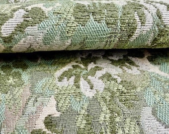Peut inclure: Un morceau de tissu d'ameublement épais plié présentant un motif jacquard tissé dense dans des tons de vert sauge, vert olive et blanc cassé. Le textile affiche un design botanique complexe et répétitif avec des éléments tissés en relief.